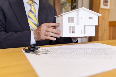 governmental-worker-holding-small-model-house