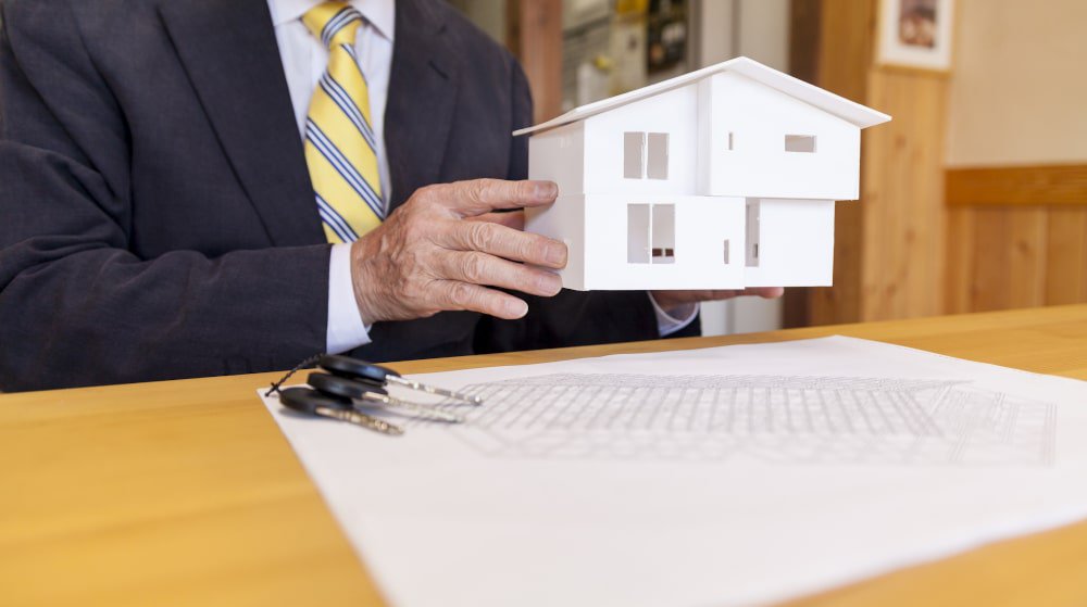 governmental-worker-holding-small-model-house